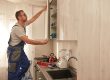 A carpenter installing kitchen cabinets