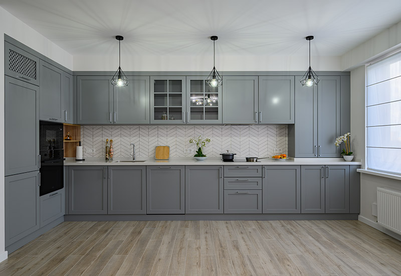 A large renovated kitchen with gray cabinetry