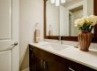 Modern bathroom vanity with dark wood cabinets, mosaic backsplash, and elegant decor