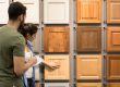 Couple examining cabinet door samples in a showroom, selecting styles and finishes